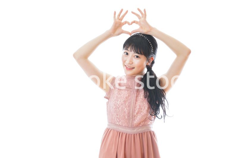 指でハートマークを作る若い女性