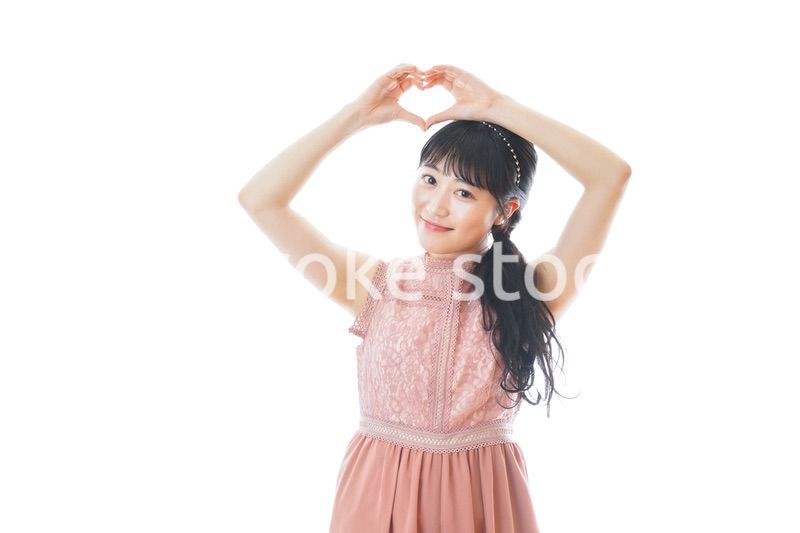 指でハートマークを作る若い女性