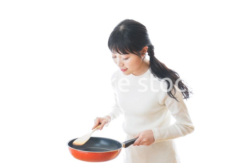 自宅で料理をする一人暮らしの女性