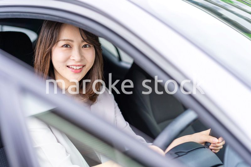 車を運転する若い女性