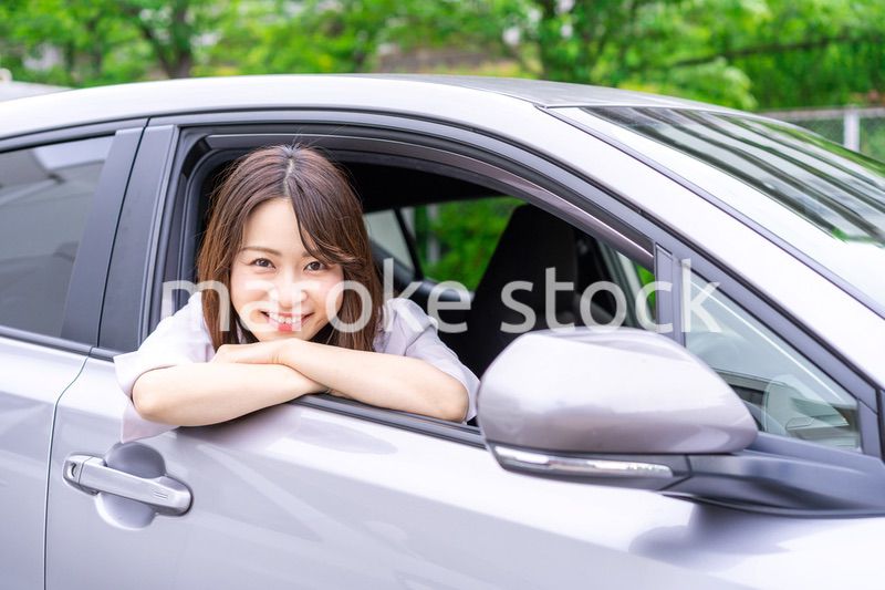 運転席から顔を出す若い女性