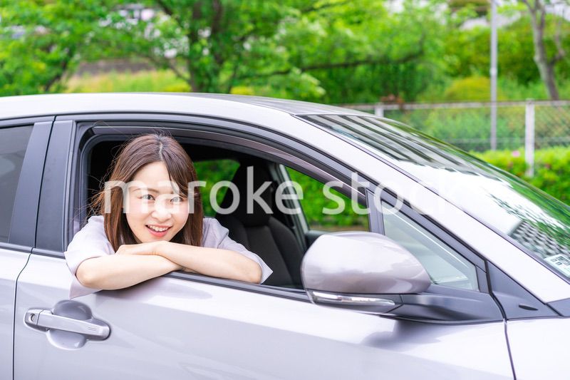 運転席から顔を出す若い女性