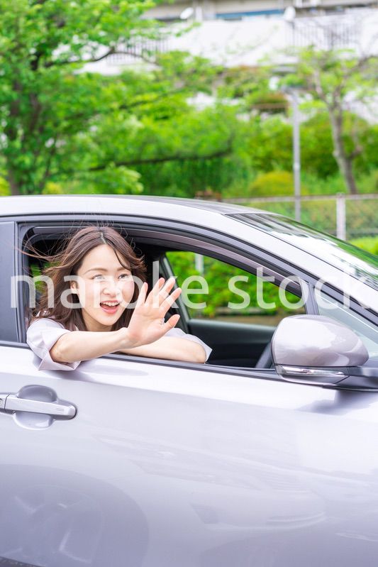 運転席から顔を出す若い女性