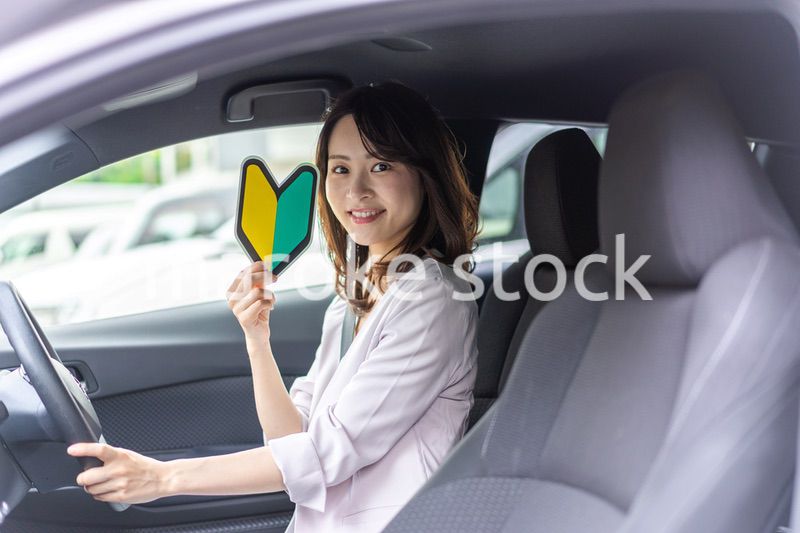 初心者マークを持った若い女性ドライバー