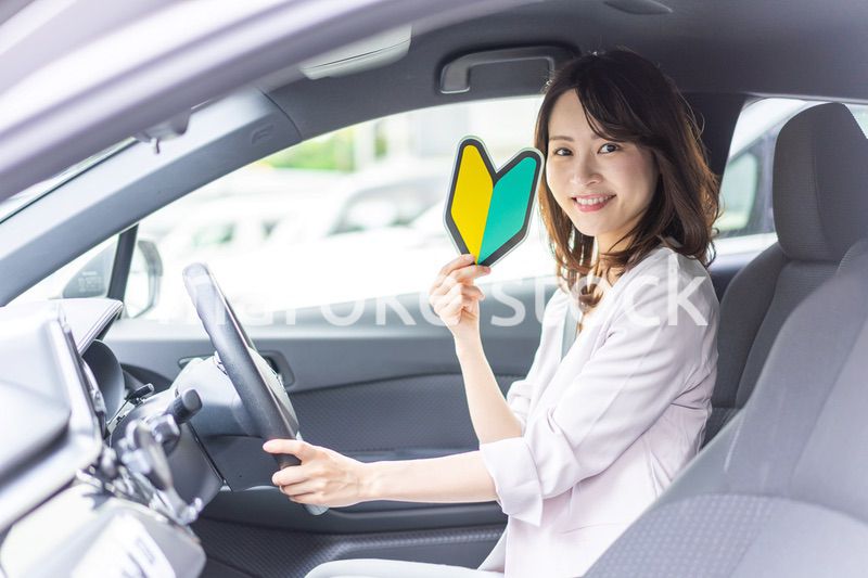 初心者マークを持った若い女性ドライバー