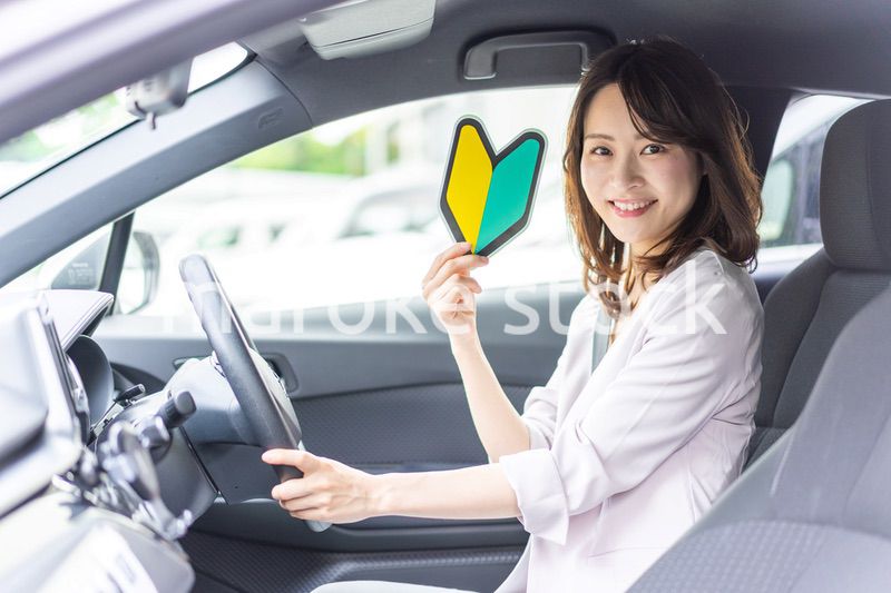 初心者マークを持った若い女性ドライバー
