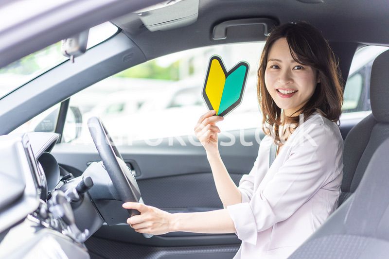 初心者マークを持った若い女性ドライバー