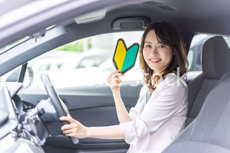 初心者マークを持った若い女性ドライバー