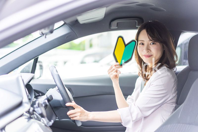 初心者マークを持った若い女性ドライバー