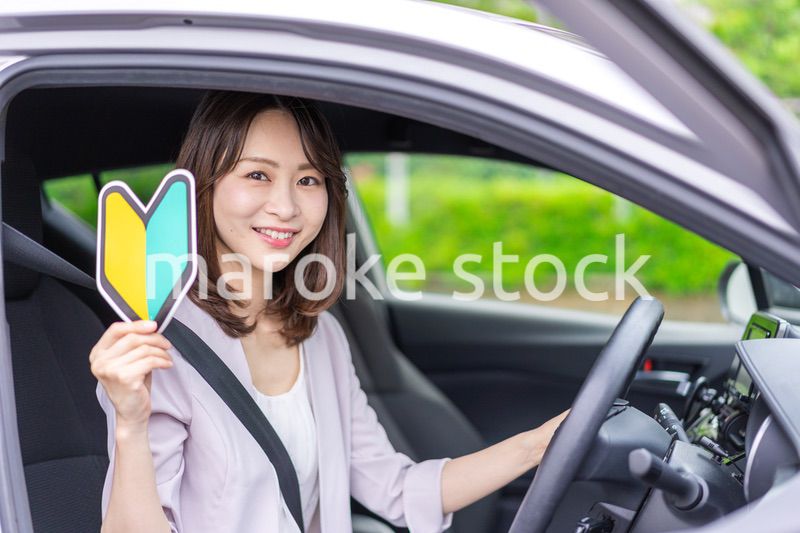 初心者マークを持った若い女性ドライバー