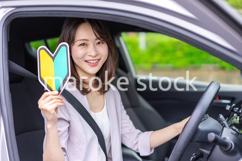 初心者マークを持った若い女性ドライバー