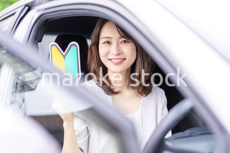 初心者マークを持った若い女性ドライバー
