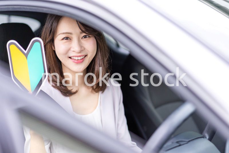 初心者マークを持った若い女性ドライバー