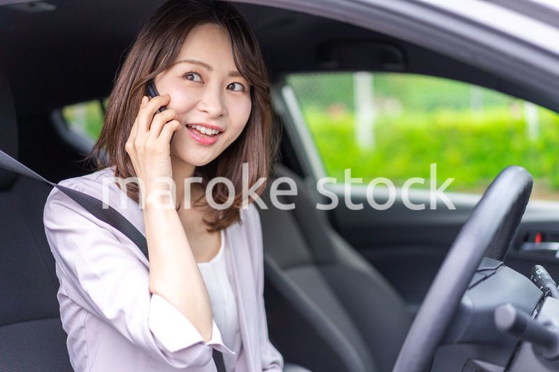 スマホを使いながら車を運転する女性