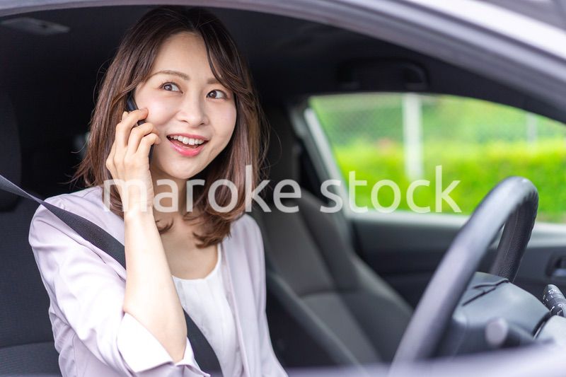 スマホを使いながら車を運転する女性