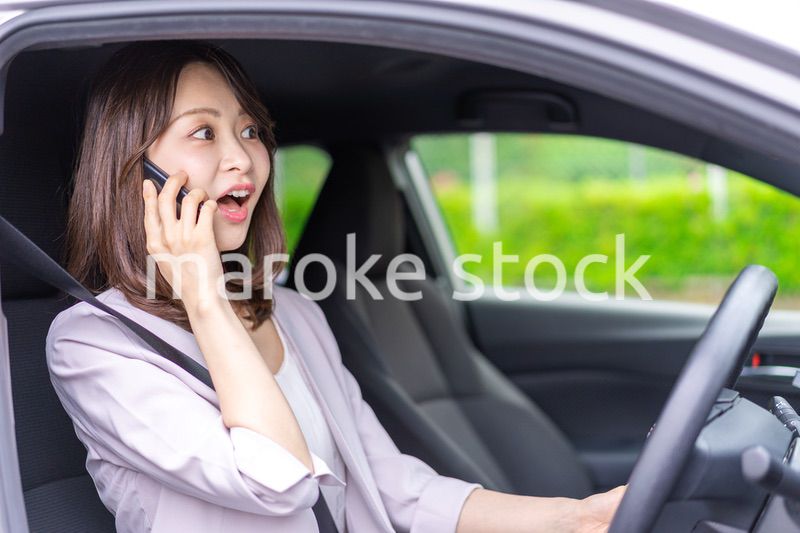 スマホを使いながら車を運転する女性
