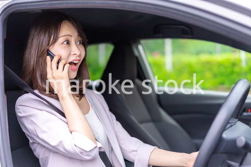 スマホを使いながら車を運転する女性