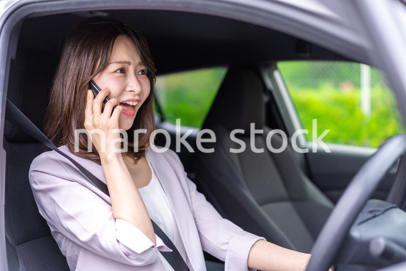 スマホを使いながら車を運転する女性