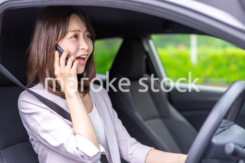 スマホを使いながら車を運転する女性