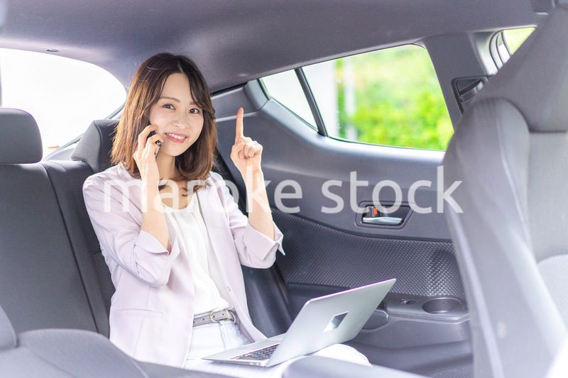 タクシーで仕事をする忙しいキャリアウーマン