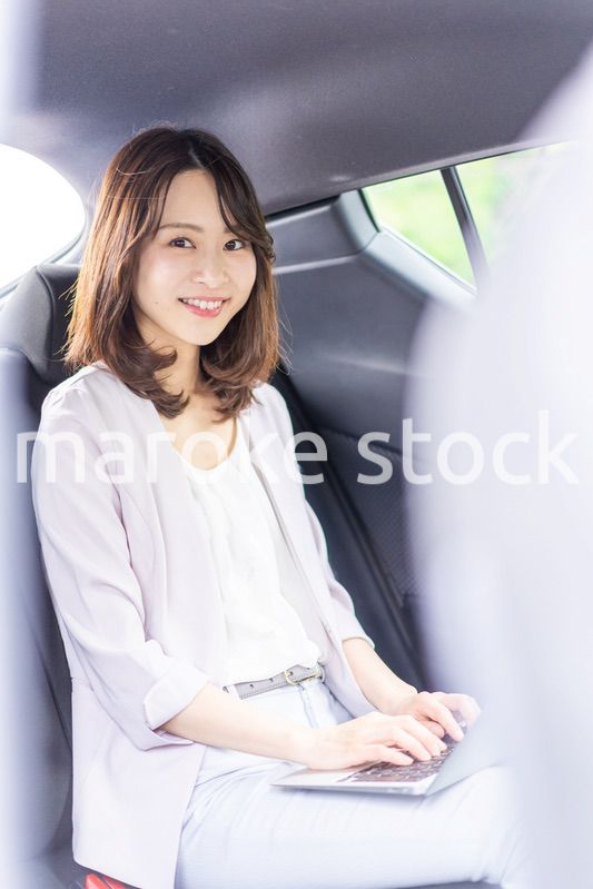 タクシーで仕事をする忙しいキャリアウーマン