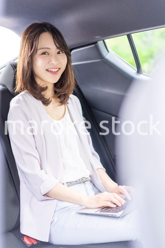 タクシーで仕事をする忙しいキャリアウーマン