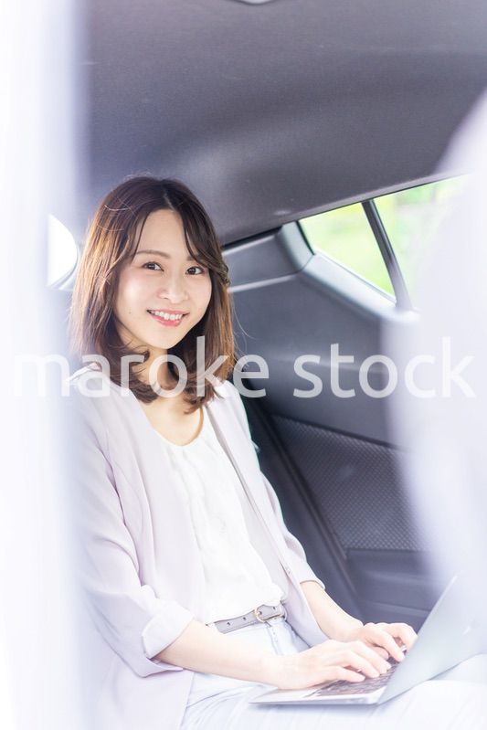 タクシーで仕事をする忙しいキャリアウーマン