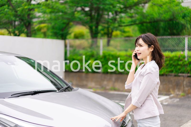 車が故障して連絡をする若い女性