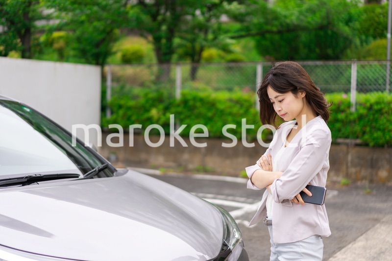 車が故障して連絡をする若い女性
