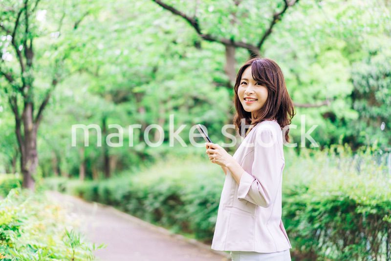 外でスマホを使うビジネスウーマン