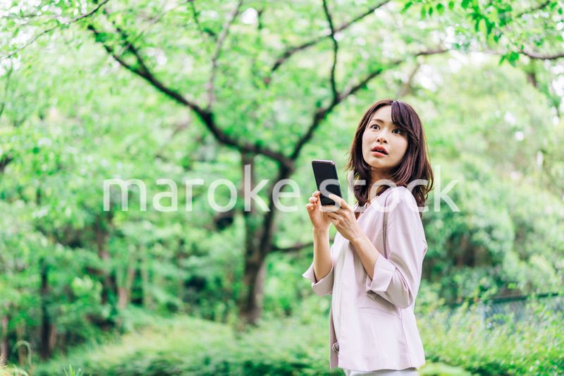 外でスマホを使うビジネスウーマン