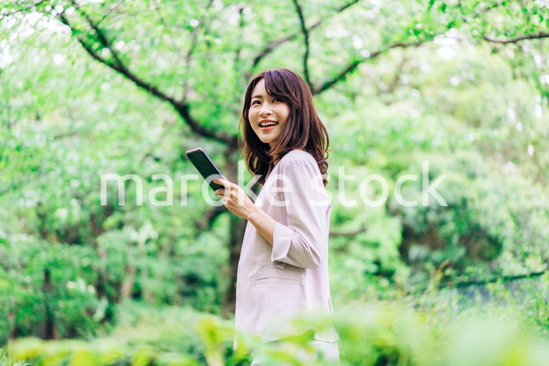 外でスマホを使うビジネスウーマン