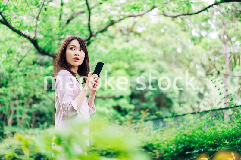 外でスマホを使うビジネスウーマン