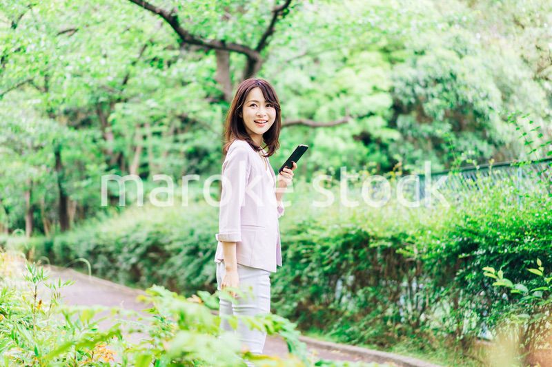 外でスマホを使うビジネスウーマン