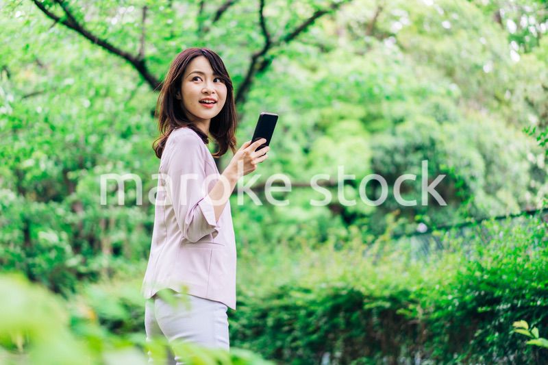 外でスマホを使うビジネスウーマン