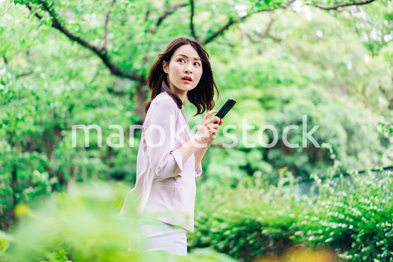 外でスマホを使うビジネスウーマン