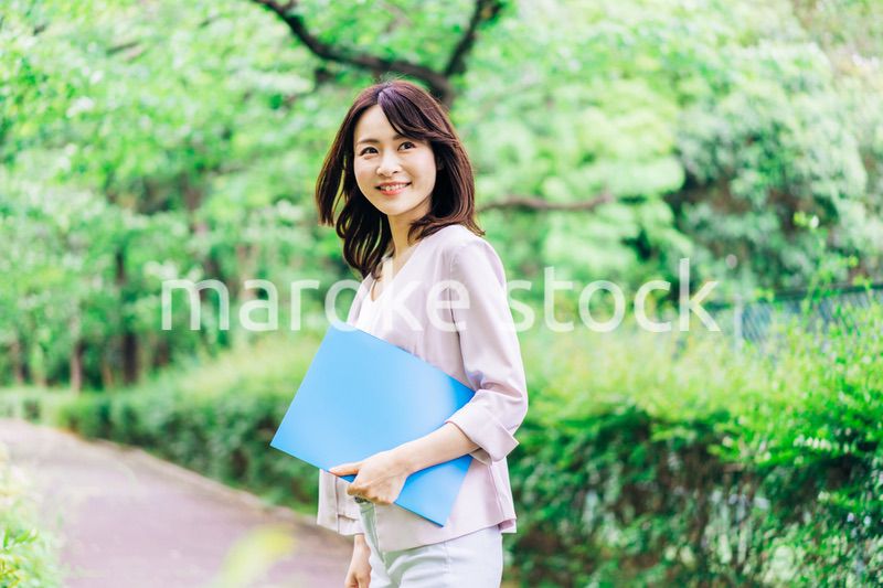 書類を持って歩く若いビジネスウーマン