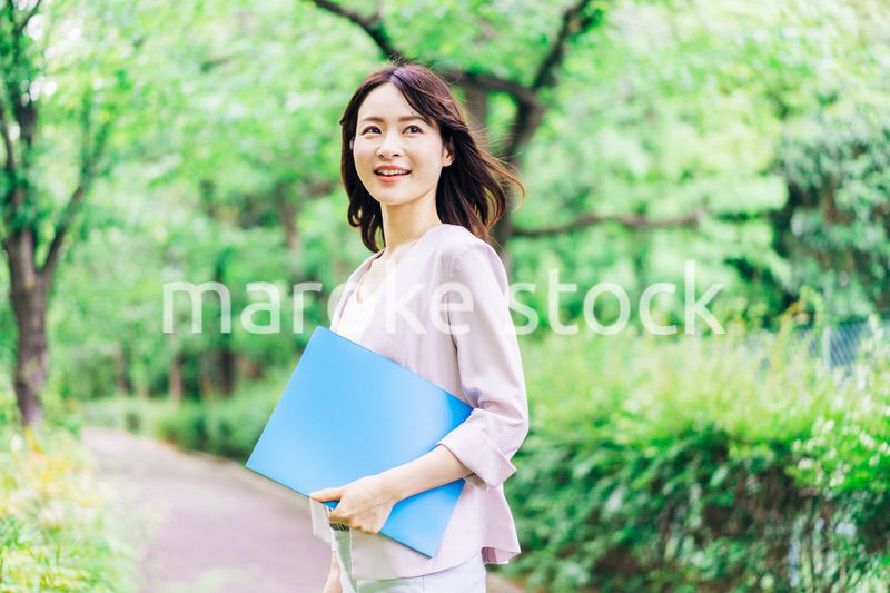 書類を持って歩く若いビジネスウーマン