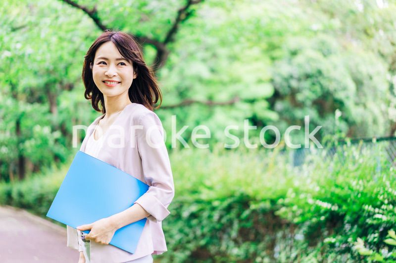 書類を持って歩く若いビジネスウーマン