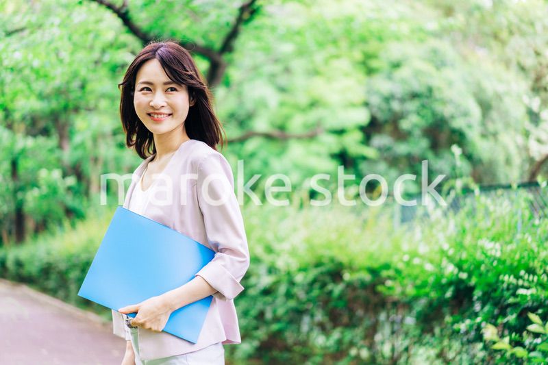 書類を持って歩く若いビジネスウーマン