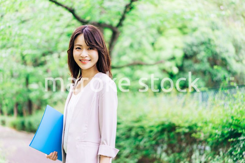 書類を持って歩く若いビジネスウーマン