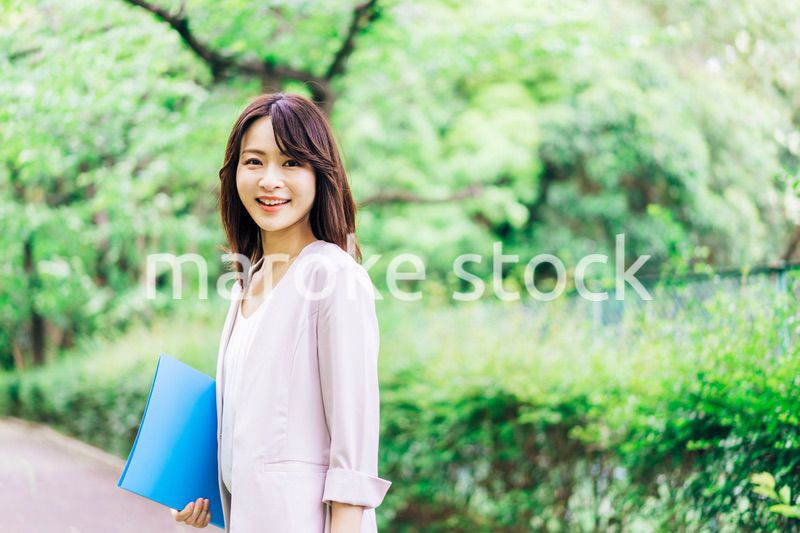 書類を持って歩く若いビジネスウーマン