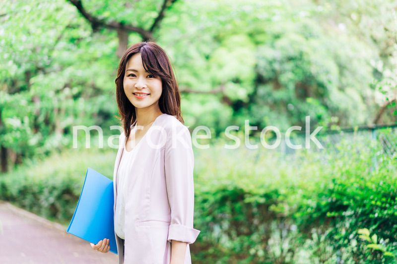 書類を持って歩く若いビジネスウーマン