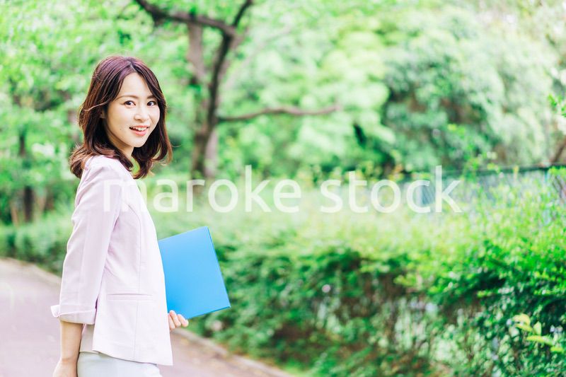 書類を持って歩く若いビジネスウーマン