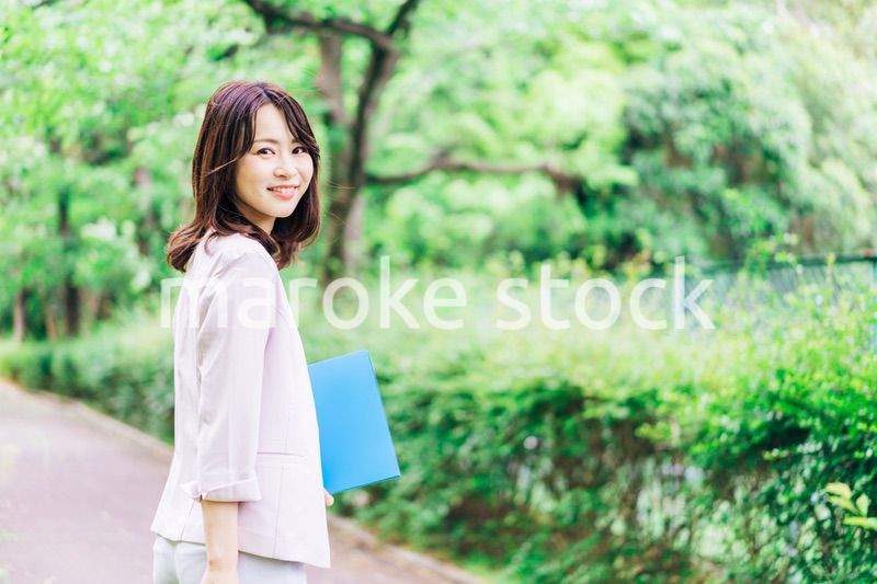 書類を持って歩く若いビジネスウーマン