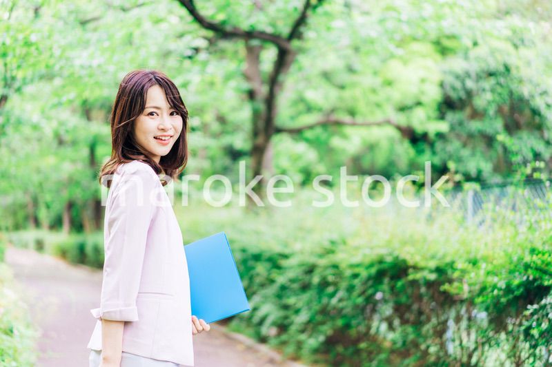 書類を持って歩く若いビジネスウーマン