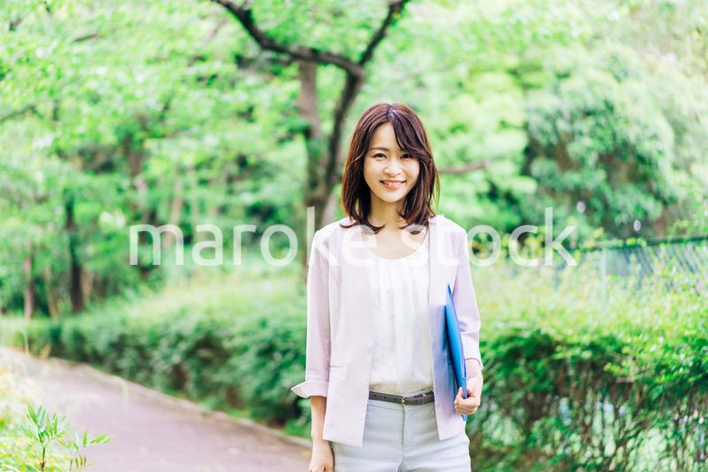 書類を持って歩く若いビジネスウーマン