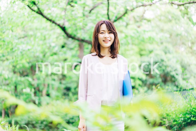 書類を持って歩く若いビジネスウーマン