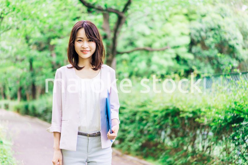 書類を持って歩く若いビジネスウーマン