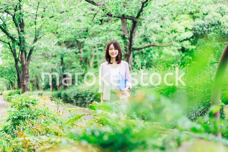 書類を持って歩く若いビジネスウーマン